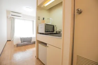a small kitchen with a microwave and a sink at walk to Higahsi Shinjuku sta. SYW in Tokyo