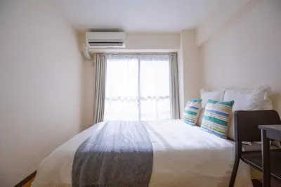a bedroom with a large bed with a window at walk to Higahsi Shinjuku sta. SYW in Tokyo