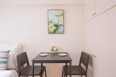 a dining room table with chairs and a painting on the wall at walk to Higahsi Shinjuku sta. SYW in Tokyo