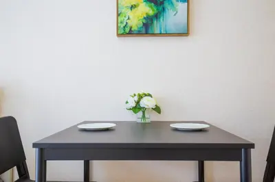 a table with two plates and a vase of flowers on it at walk to Higahsi Shinjuku sta. SYW in Tokyo