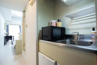 a kitchen with a sink and a microwave at walk to Higahsi Shinjuku sta. LoL in Tokyo