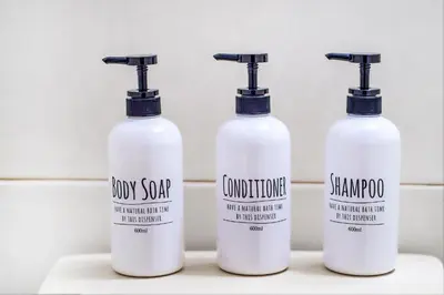 a group of three shampoo bottles sitting on a shelf at walk to Higahsi Shinjuku sta. LoL in Tokyo