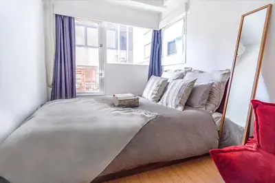 a bedroom with a large bed with a large mirror at walk to Higahsi Shinjuku sta. EoQ in Tokyo