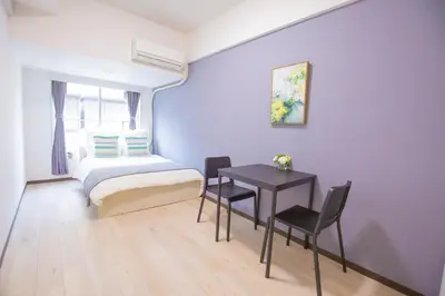 a bedroom with a bed and a table and chairs at walk to Higahsi Shinjuku sta. EYW in Tokyo
