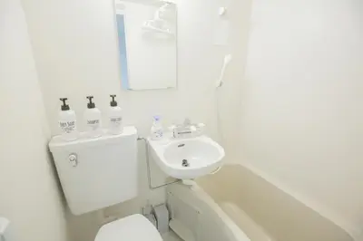 a white bathroom with a sink and a bath tub at walk to Higahsi Shinjuku sta. EYW in Tokyo