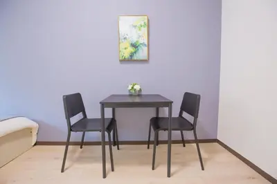 a table and chairs in a room with a painting at walk to Higahsi Shinjuku sta. EYW in Tokyo