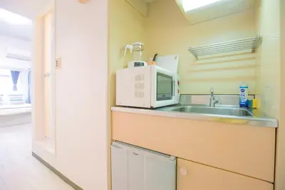 a kitchen with a sink and a microwave at walk to Higahsi Shinjuku sta. EYW in Tokyo