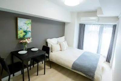 a hotel room with a bed and a table and a tableablish at walk to Higahsi Shinjuku sta. LYo in Tokyo
