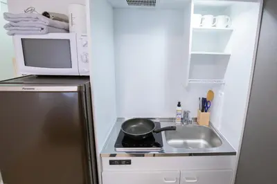 a kitchen with a sink and a frying pan on a stove at walk to Higahsi Shinjuku sta. LYo in Tokyo