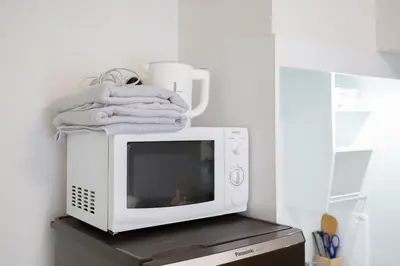 a microwave with towels sitting on top of it at walk to Higahsi Shinjuku sta. LYo in Tokyo