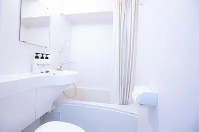 a white bathroom with a toilet and a sink at walk to Higahsi Shinjuku sta. LYo in Tokyo