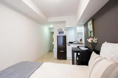 a bedroom with a bed and a small kitchen at walk to Higahsi Shinjuku sta. LYo in Tokyo