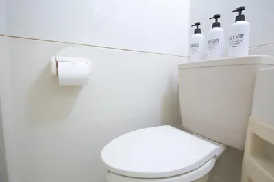 a bathroom with a white toilet with three bottles on it at walk to Higahsi Shinjuku sta. WoSI in Tokyo