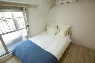 a bed in a small room with a window at walk to Higahsi Shinjuku sta. WoSI in Tokyo