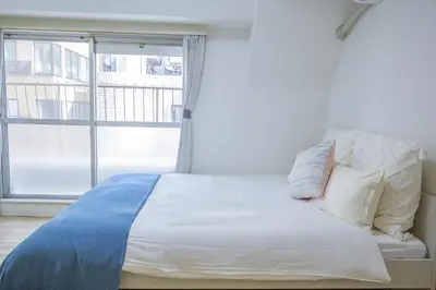 a bedroom with a bed with a large window at walk to Higahsi Shinjuku sta. WoSI in Tokyo