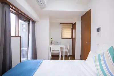 a bedroom with a bed and a table at walk to Higahsi Shinjuku sta. SIoQ-2 in Tokyo