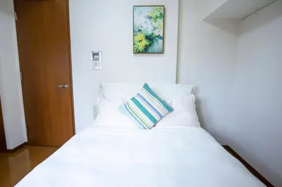 a white bed with a pillow on top of it at walk to Higahsi Shinjuku sta. SIoQ-2 in Tokyo