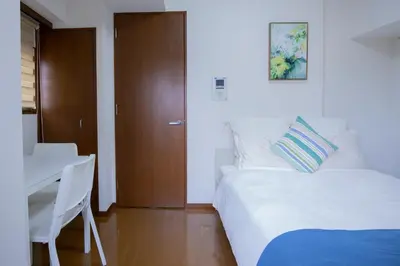 a bedroom with a bed and a table and a desk at walk to Higahsi Shinjuku sta. SIoQ-2 in Tokyo