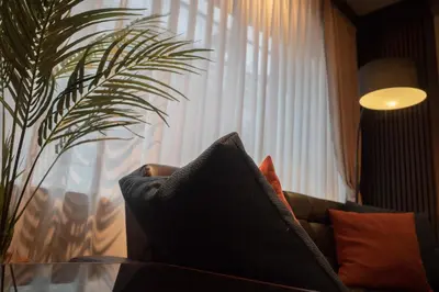 a couch with pillows in a living room with a plant at Acoustic GARAGE by Tranova in Tokyo