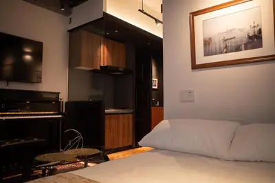 a living room with a bed and a piano at Acoustic GARAGE by Tranova in Tokyo