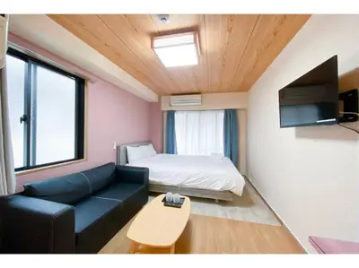 a living room with a couch and a bed at We Guest House in Tokyo