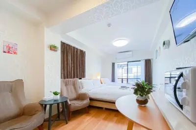 a large white bedroom with a bed and a couch at We Guest House in Tokyo
