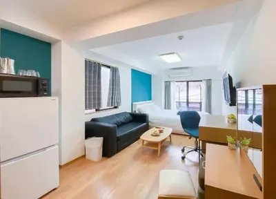 a small living room with a couch and a kitchen at We Guest House in Tokyo