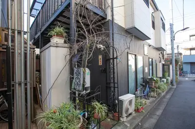 a building with a black door with plants on it at ks\u897f\u65e9\u7a32\u7530 in Tokyo