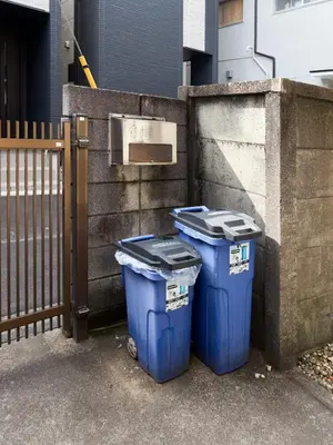 two blue trash cans sitting next to a fence at Tokyo Central Shinjuku-ward Japanese Tatami House 2DK-\u65b0\u5bbf03 in Tokyo