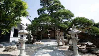 a japanese garden with two statues in front of a building at Tokyo Central Shinjuku-ward Japanese Tatami House 2DK-\u65b0\u5bbf03 in Tokyo