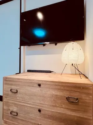 a tv on top of a dresser with a lamp on it at Ueno Retro Flower - Ueno Okachimachi in Tokyo
