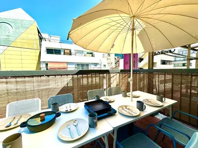 a table with plates and an umbrella on a balcony at Ueno Retro Flower - Ueno Okachimachi in Tokyo