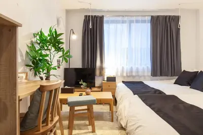 a bedroom with a bed and a desk with a desk at Trym\u62bc\u4e0a in Tokyo
