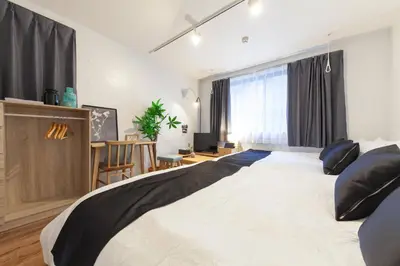 a bedroom with a large white bed with black pillows at Trym\u62bc\u4e0a in Tokyo