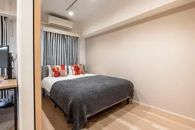 a bedroom with a bed with orange pillows at \u30af\u30ec\u30a2\u30c4\u30a3\u30aa\u30fc\u30cd\u8d64\u5742 in Tokyo