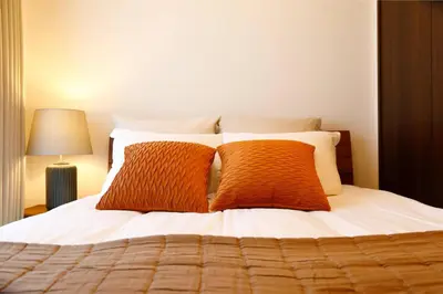 a bedroom with a bed with two orange pillows at MAT Oshiage in Tokyo