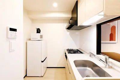 a small kitchen with a sink and a refrigerator at MAT Oshiage in Tokyo