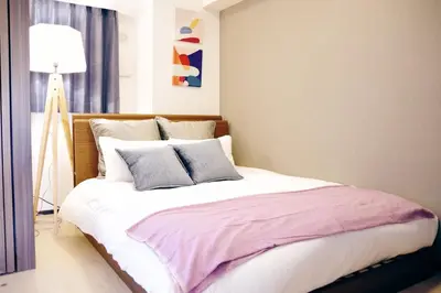 a bedroom with a large bed with purple and white pillows at MAT Oshiage in Tokyo