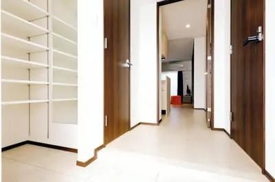 a hallway of a house with wooden doors and shelves at MAT Oshiage in Tokyo