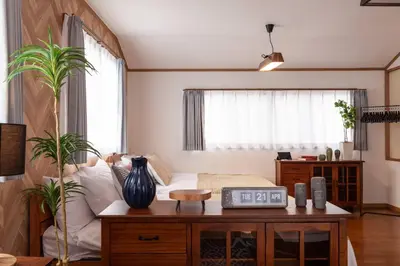 a living room with a bed and a table with a clock at \u5317\u65b0\u5bbf1-11-10 in Tokyo