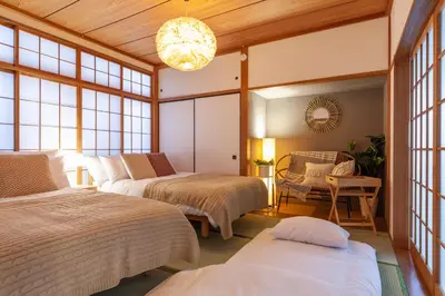 a bedroom with three beds and a chandelier at \u5317\u65b0\u5bbf1-11-10 in Tokyo