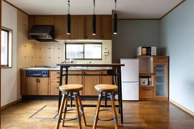 a kitchen with wooden cabinets and a counter with stools at \u5317\u65b0\u5bbf1-11-10 in Tokyo
