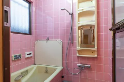 a pink bathroom with a tub and a mirror at \u5317\u65b0\u5bbf1-11-10 in Tokyo