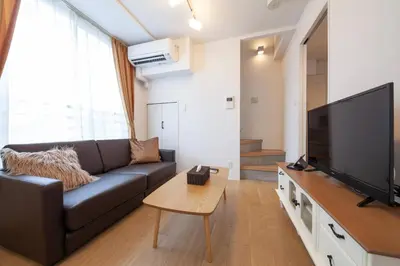 a living room with a couch and a flat screen tv at Legaland\u5b66\u7fd2\u9662\u4e0b in Tokyo