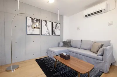 a living room with a blue couch and a table at Legaland\u5b66\u7fd2\u9662\u4e0b in Tokyo