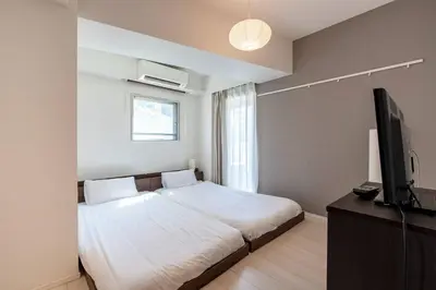 a bedroom with a bed and a flat screen tv at \u6e0b\u8c37\u30d2\u30eb\u30c8\u30c3\u30d7 in Tokyo
