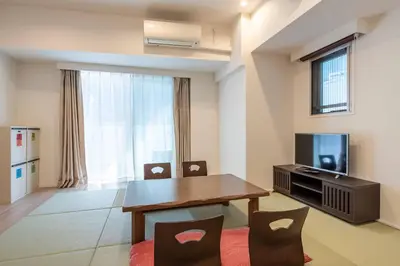 a living room with a table and chairs and a television at \u6e0b\u8c37\u30d2\u30eb\u30c8\u30c3\u30d7 in Tokyo