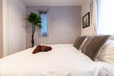 a white bed with a bag on top of it at R\u30ca\u30ec\u30c3\u30b8\u4e21\u56fd bldg in Tokyo