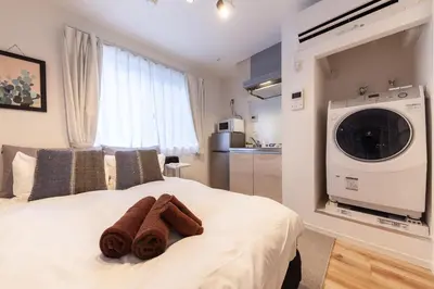 a bedroom with a bed with a washing machine on it at R\u30ca\u30ec\u30c3\u30b8\u4e21\u56fd bldg in Tokyo