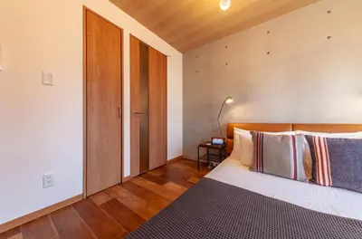 a bedroom with a bed with a wooden headboard at Villettina\u6d45\u8349 in Tokyo